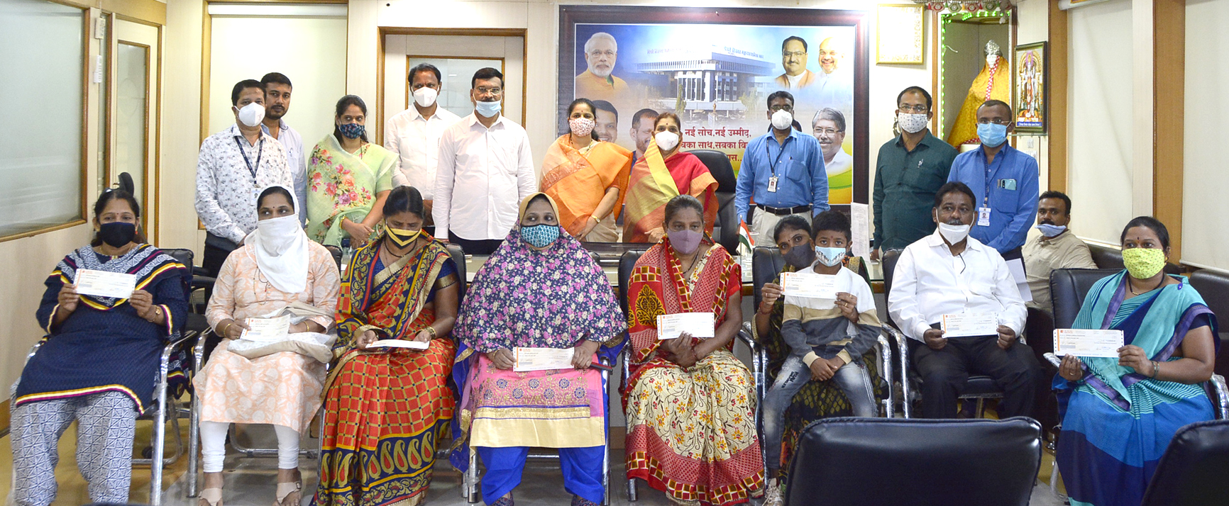 Distribution of checks of Rs. 25 lakhs each to the heirs of 9 employees of NMC