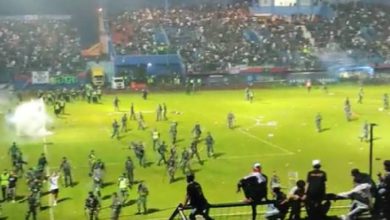 Fans riot on the field during a football match in Indonesia